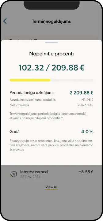 Viedtālrunis, kurā redzams INDEXO Bankas aplikācijas termiņnoguldījumu ekrāns ar tiktāl nopelnītajiem procentiem